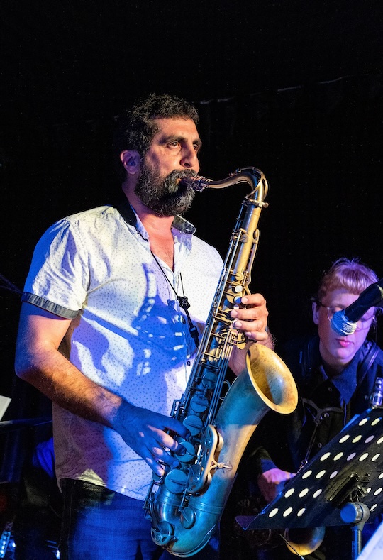 lessons Omid playing saxophone on stage